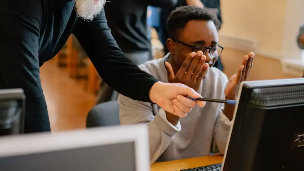 Älterer Kollege erklärt jungem Kollegen am Rechner