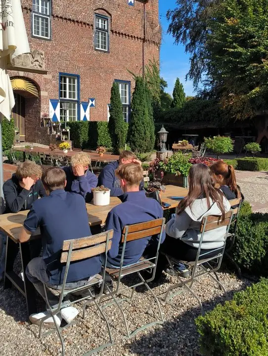 Seminargruppe arbeitet im Schlosshof gemeinsam an einer Aufgabe